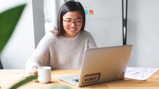 web designer opening her laptop at the start of working day